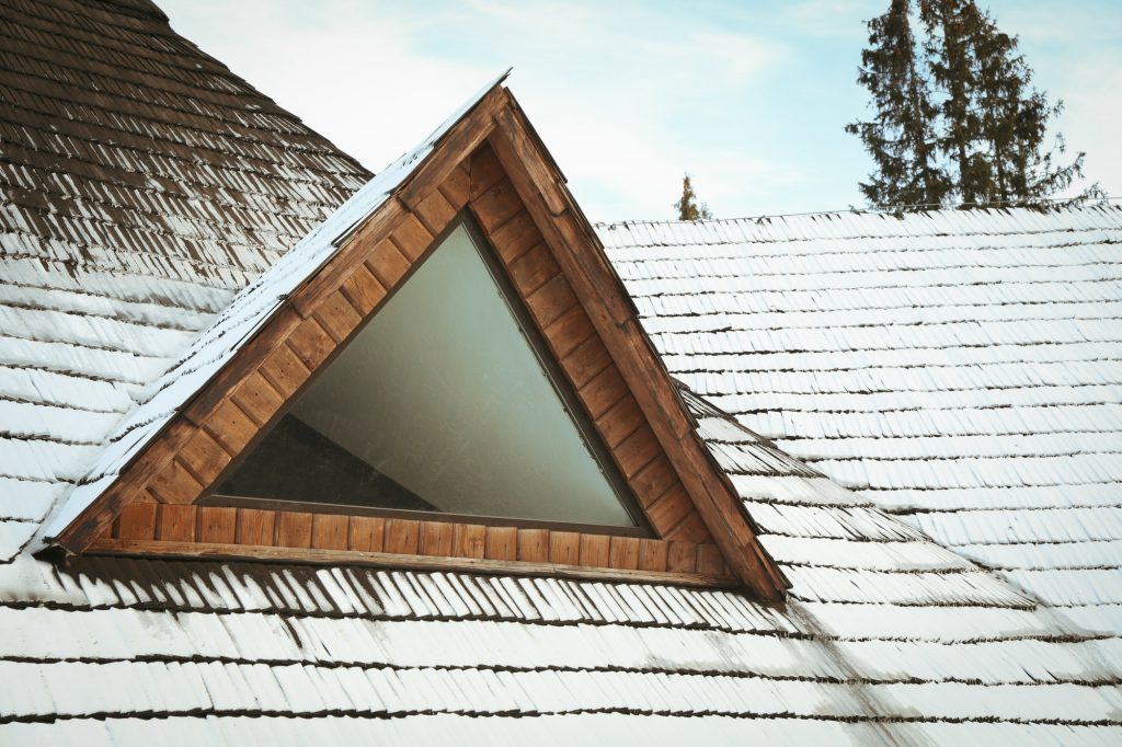 Roof of wooden house with snow in winter day